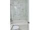 Close up on a bathtub with a shower and nice marble tiling at 3 Dogwood Drive Loop, Ocala, FL 34472
