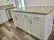Granite island with white cabinets in a kitchen with stainless steel dishwasher at 3 Dogwood Drive Loop, Ocala, FL 34472