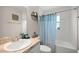 Bathroom featuring a sink with a mirror, a shower with blue patterned curtain, and decorative shelves and plants at 5537 Se 91St Pl, Ocala, FL 34480