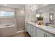 Bright bathroom with a walk-in shower, double sink vanity with granite countertop, and large mirror and lighting at 5537 Se 91St Pl, Ocala, FL 34480