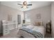 Cozy bedroom with a ceiling fan, a bed with patterned pillows and blanket, and a desk near the window at 5537 Se 91St Pl, Ocala, FL 34480