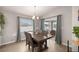Dining area features a wooden table, modern light fixture, and sliding glass door to the patio at 5537 Se 91St Pl, Ocala, FL 34480