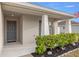 Charming front entrance with a gray front door, manicured bushes, and cozy lighting at 5537 Se 91St Pl, Ocala, FL 34480