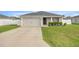 Charming single-story home features a two-car garage, manicured lawn, and front garden at 5537 Se 91St Pl, Ocala, FL 34480