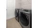 A well-equipped laundry room features modern, front-load washer and dryer and shelving above at 5537 Se 91St Pl, Ocala, FL 34480