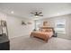 Spacious primary bedroom with carpet flooring, ceiling fan, and windows allowing natural light at 5537 Se 91St Pl, Ocala, FL 34480