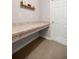 Mudroom with countertop desk area featuring hooks for hanging items and a bright white door at 5537 Se 91St Pl, Ocala, FL 34480