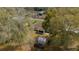 Aerial view of a home's backyard, featuring a shed and screened-in porch nestled among mature trees at 6718 Cherry Rd, Ocala, FL 34472