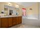 The bathroom features a double sink vanity, soaking tub, and tiled flooring for a luxurious experience at 6718 Cherry Rd, Ocala, FL 34472