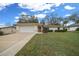 Beige single story home with a two-car garage, manicured lawn and well maintained landscaping at 6718 Cherry Rd, Ocala, FL 34472