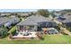 Aerial view of a home, back patio with seating, screened-in patio with a hot tub, and a lush green lawn at 6865 Sw 97Th Terrace Rd, Ocala, FL 34481