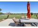 Back patio with an umbrella-covered table and seating, with scenic views of the green and palm trees at 6865 Sw 97Th Terrace Rd, Ocala, FL 34481