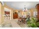 Formal dining room with stylish chandelier, wood table, and open view to the kitchen at 6865 Sw 97Th Terrace Rd, Ocala, FL 34481