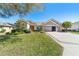 Charming home featuring manicured landscaping, a three-car garage, and a well-maintained lawn at 6865 Sw 97Th Terrace Rd, Ocala, FL 34481