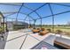 Spacious screened-in patio featuring a hot tub, lounge chairs, and outdoor seating with views of the golf course at 6865 Sw 97Th Terrace Rd, Ocala, FL 34481
