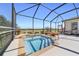 Close-up of the screened pool and waterfall feature overlooking the golf course and blue skies at 6865 Sw 97Th Terrace Rd, Ocala, FL 34481