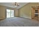 Open living room boasts fresh carpet, ceiling fan, and a large sliding glass door at 7082 Sw 131St Loop, Ocala, FL 34473