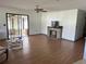 Bright living room featuring wood flooring and seamless access to the enclosed patio at 9140 Sw 103Rd Ln, Ocala, FL 34481
