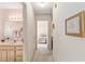 Hallway view to the bathroom and bedroom featuring light colored walls and white doors at 9581 Sw 85Th Ave # D, Ocala, FL 34481