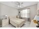 Bright bedroom with ceiling fan, neutral colors, and a large window offering natural light at 9974 Sw 88Th Loop, Ocala, FL 34481