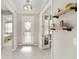 Inviting foyer featuring decorative glass door, neutral walls, and stylish light fixture, complemented by decorative shelving at 9974 Sw 88Th Loop, Ocala, FL 34481