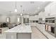 Modern kitchen featuring white cabinetry, granite countertops, stainless steel appliances, and island with bar seating at 9974 Sw 88Th Loop, Ocala, FL 34481