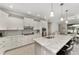 Bright kitchen features sleek white cabinetry, a gray backsplash, and granite countertops with barstool seating at 9974 Sw 88Th Loop, Ocala, FL 34481
