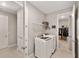 Functional laundry room equipped with washer, dryer, and extra storage shelving at 9974 Sw 88Th Loop, Ocala, FL 34481