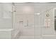 Modern walk-in shower with glass enclosure, bench, and grab bars for accessibility at 9974 Sw 88Th Loop, Ocala, FL 34481