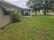 Spacious backyard with lush green lawn and view of the outdoor sunroom at 10040 Sw 98Th Ave, Ocala, FL 34481