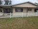 Charming home exterior featuring a well-kept lawn and classic white picket fence at 10040 Sw 98Th Ave, Ocala, FL 34481