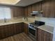 Updated kitchen showcasing stainless steel appliances and dark wood cabinetry at 10040 Sw 98Th Ave, Ocala, FL 34481
