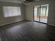 Bright living room with wood-look flooring, ceiling fan, and sliding doors to sunroom at 10040 Sw 98Th Ave, Ocala, FL 34481