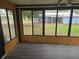 Enclosed sun room featuring black-framed windows offering panoramic views of the backyard at 10040 Sw 98Th Ave, Ocala, FL 34481