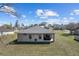 Rear view of a single-story home with a covered patio and large backyard at 10400 Sw 50Th Ct, Ocala, FL 34476