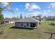 Exterior rear view of a single-story home with a covered patio and large backyard at 10400 Sw 50Th Ct, Ocala, FL 34476