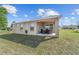 Exterior of home with covered back porch and well-maintained lawn for relaxing and outdoor living at 10400 Sw 50Th Ct, Ocala, FL 34476