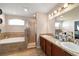 Bright bathroom featuring dual sinks, granite countertops, soaking tub, and glass shower at 10400 Sw 50Th Ct, Ocala, FL 34476