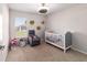 Cozy Bedroom with a crib, comfy chair, and a view to the outdoors at 10400 Sw 50Th Ct, Ocala, FL 34476