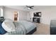 A primary bedroom offers neutral walls and carpet, a ceiling fan, TV, and ensuite bathroom at 10400 Sw 50Th Ct, Ocala, FL 34476