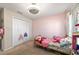 Pink bedroom with a brass bed, bright decor, closet, and a ceiling fan at 10400 Sw 50Th Ct, Ocala, FL 34476