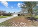 Single-story home with a two-car garage, large driveway, and a simple yet charming front yard at 10400 Sw 50Th Ct, Ocala, FL 34476