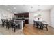 Open-concept kitchen with bar seating, granite countertops, wood floors, and a dining area at 10400 Sw 50Th Ct, Ocala, FL 34476