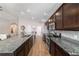Modern kitchen with stainless appliances, granite countertops, wood floors, and views into the living room at 10400 Sw 50Th Ct, Ocala, FL 34476