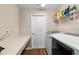 Efficient laundry room with sleek appliances, countertop, and shelving for storage at 10400 Sw 50Th Ct, Ocala, FL 34476