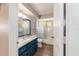 Bathroom with a stylish blue vanity, framed mirror, tiled shower-tub and wood-look flooring at 11475 Sw 85Th Ave, Ocala, FL 34481