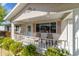 Inviting front porch showcasing a cozy seating area, neat landscaping, and stylish exterior decor creating a welcoming ambiance at 11475 Sw 85Th Ave, Ocala, FL 34481