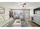 Well-lit living room with a front door view, featuring a comfortable white sofa, decorative shelves, and a neutral color palette at 11475 Sw 85Th Ave, Ocala, FL 34481