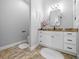 Well-lit bathroom with a granite countertop vanity, stylish mirrors and tiled floor at 11707 Se 101St Court Rd, Belleview, FL 34420