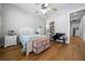 Cozy bedroom with a ceiling fan and charming decor, complemented by warm hardwood floors at 11707 Se 101St Court Rd, Belleview, FL 34420